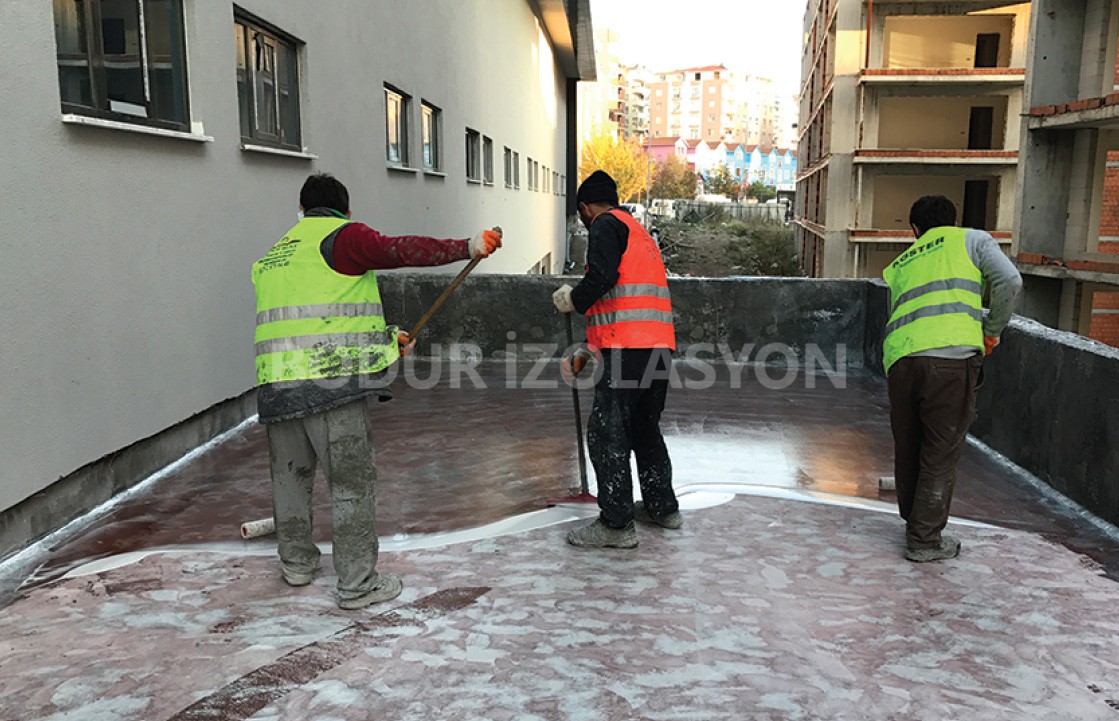 işçiler poliüretan malzeme ile zemine su yalıtımı yapıyor